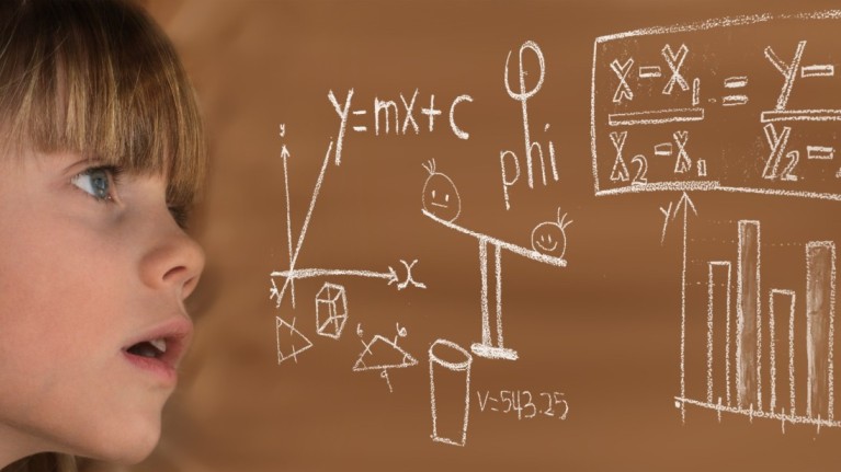 kid looking at some physical formulas written on  board